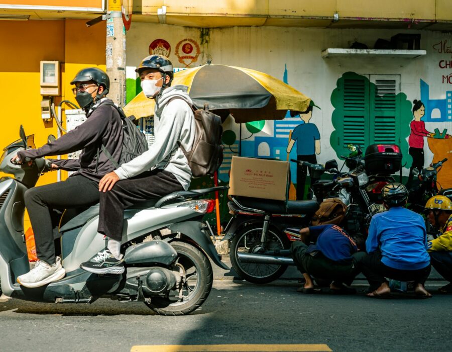 Delivery riders on a scooter with delivery bags