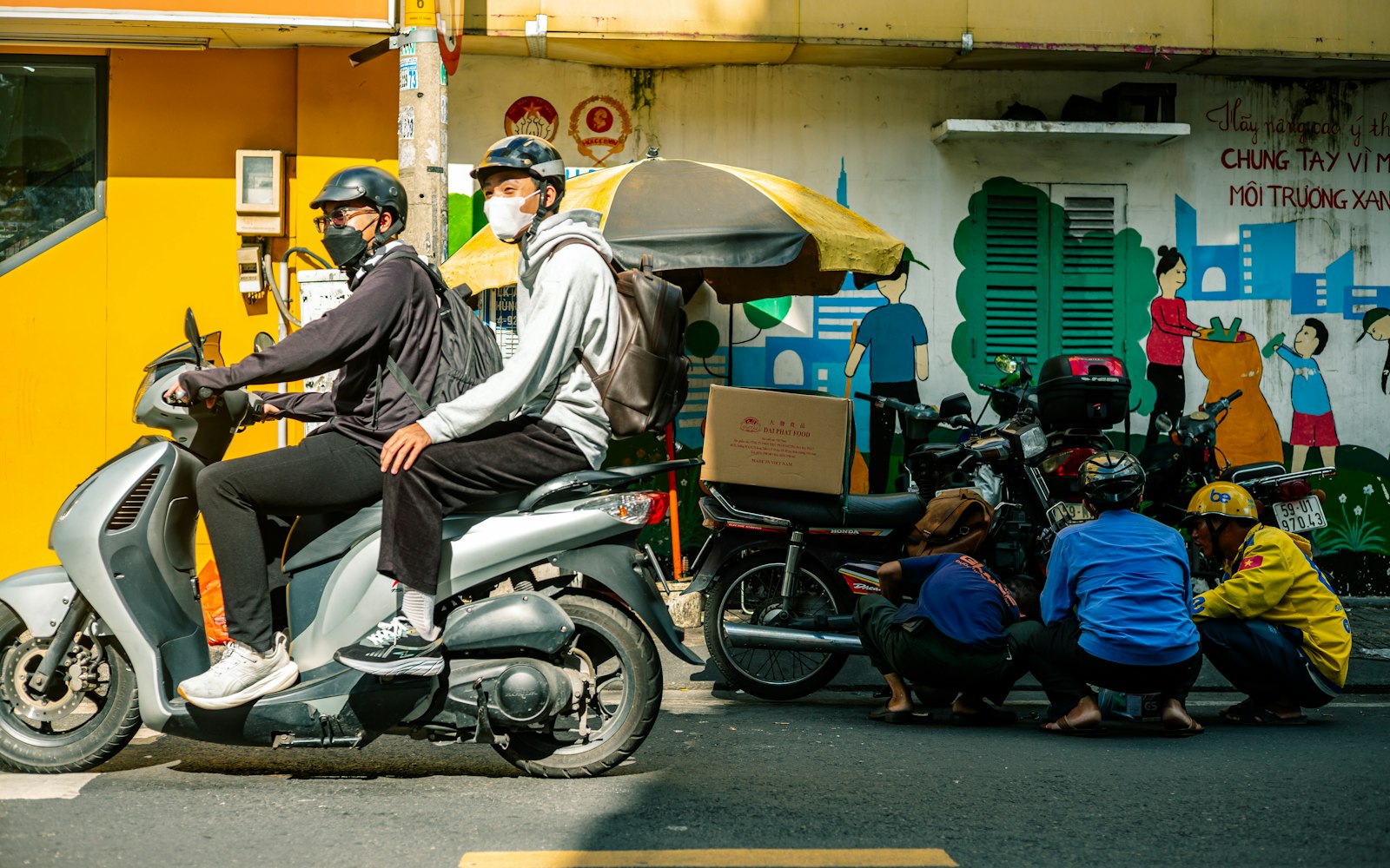Delivery riders on a scooter with delivery bags