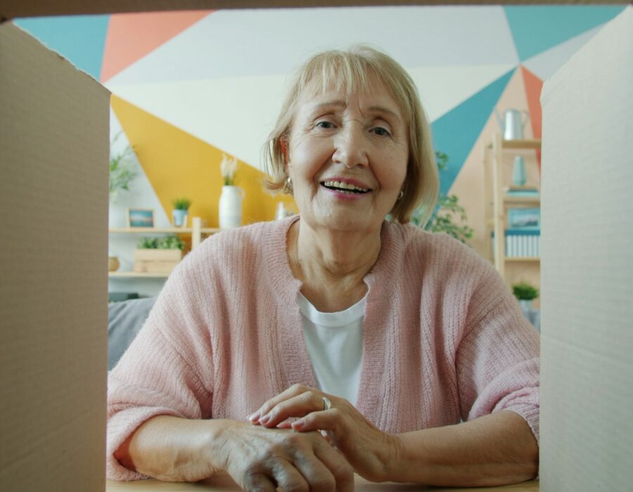 Smiling woman opening a delivered parcel at home