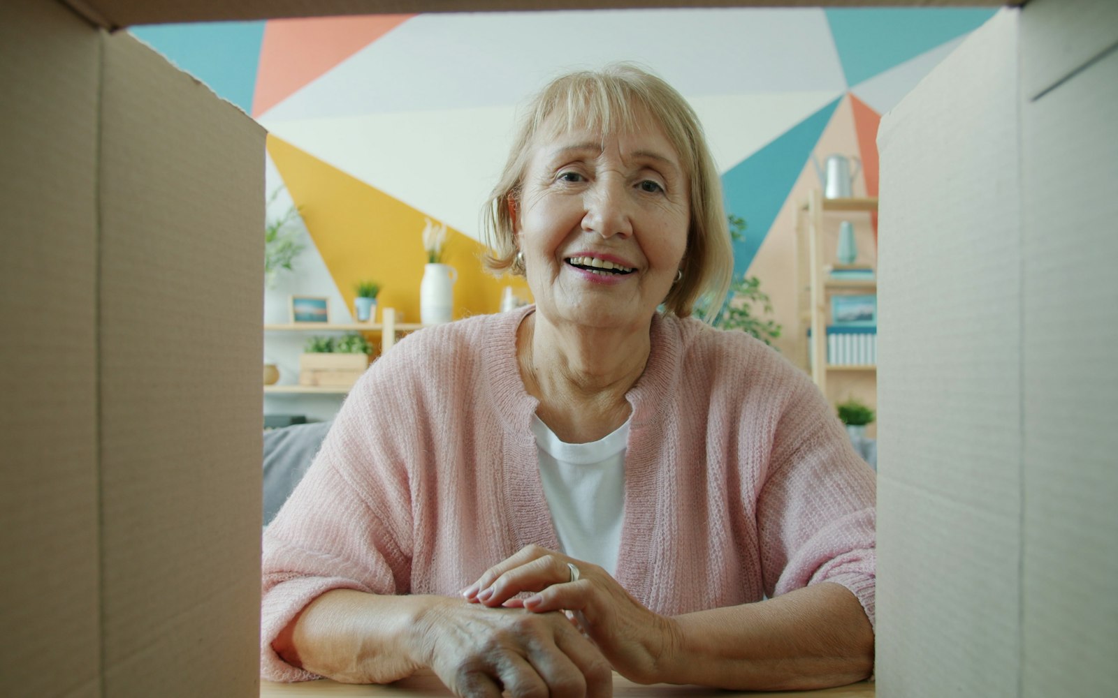 Smiling woman opening a delivered parcel at home